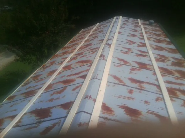 Rusted metal roof panels with new wood purlins before replacement — Storm Damage Roof Repair in Great River by Roofing Brothers