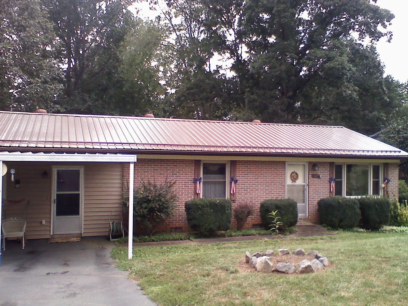 Bronze metal roof and carport on a brick ranch home — Roof Repair work by our crew in Great River